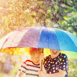 Foto: zwei Kinder unter einem bunten Regenschirm